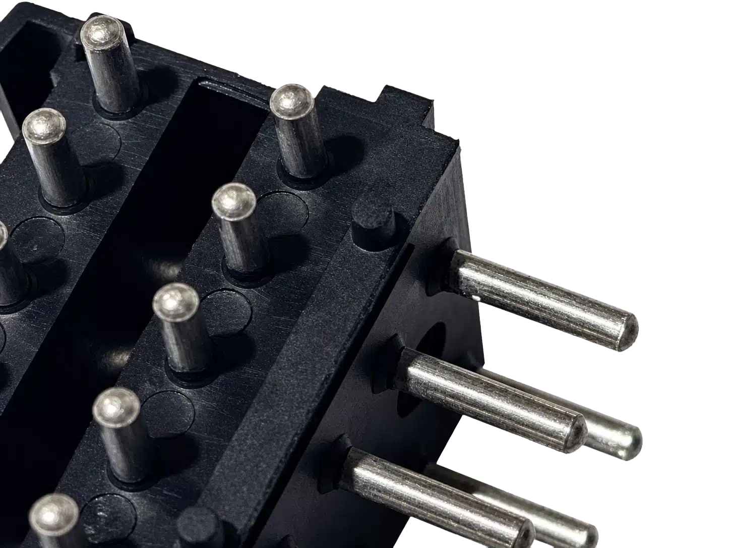 Multiple connector pins insert molded into a black engineered plastic component